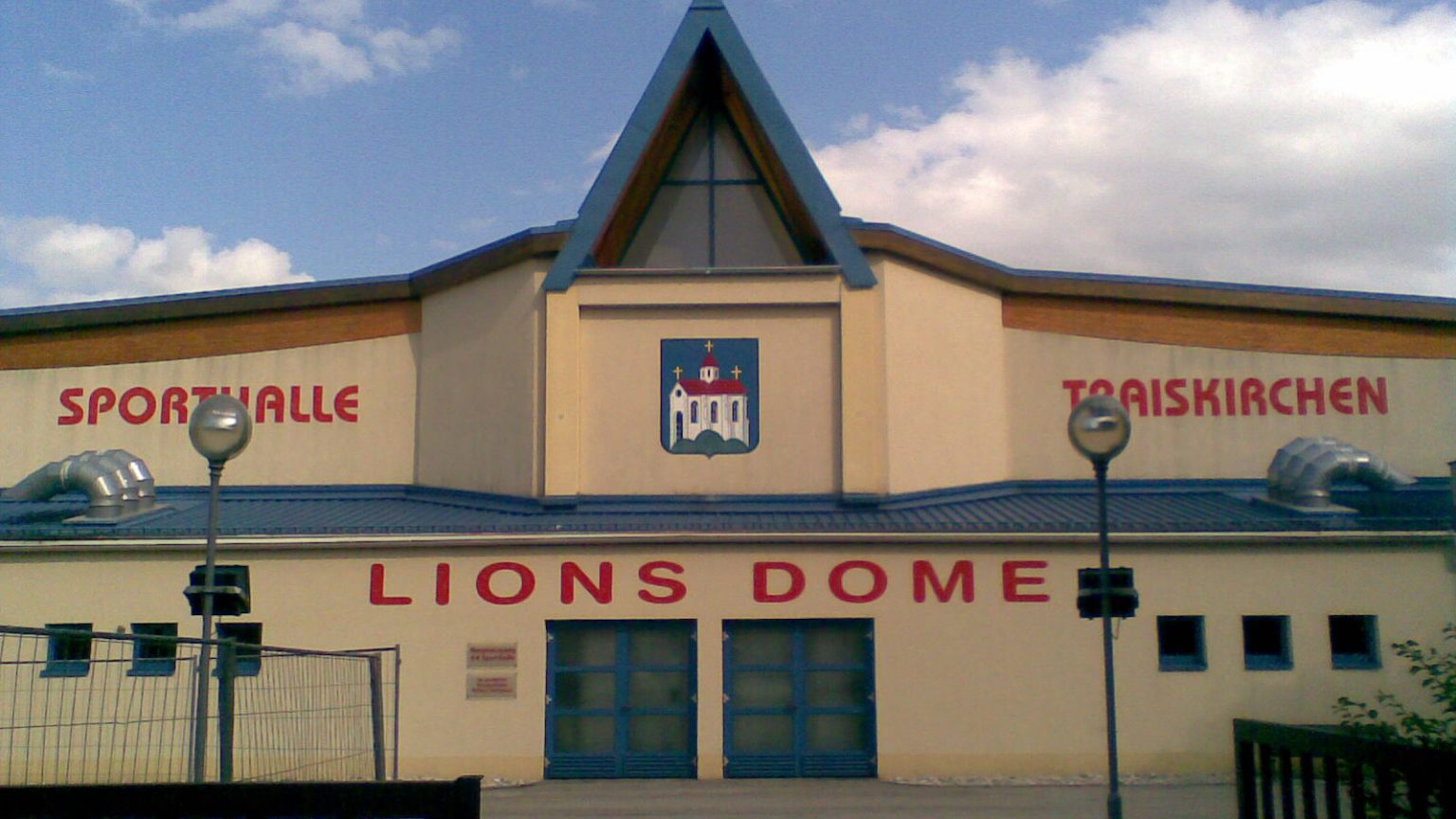 Außenansicht des Lions Dome in Traiskirchen mit Stadtwappen und rotem Schriftzug, Heimhalle der Lions