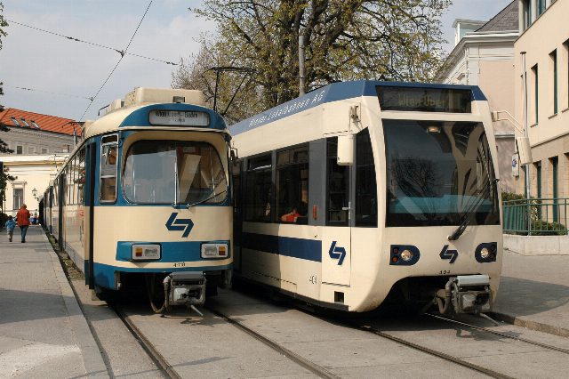Zwei Züge der Badner Bahn in Creme und Blau stehen nebeneinander in der Endstelle Baden Josefsplatz