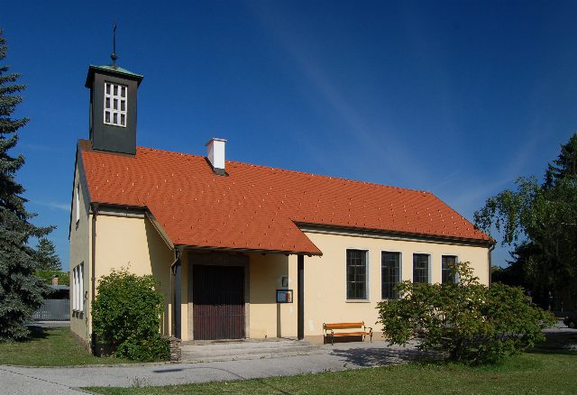 Die evangelische Kirche in Leobersdorf, ein heller Bau mit rotem Ziegeldach und kleinem Glockenturm