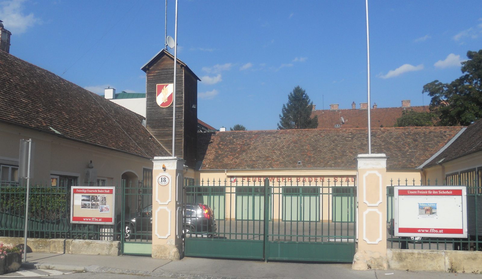 Feuerwehrhaus der Freiwilligen Feuerwehr Baden-Stadt in der Grabengasse mit grünem Tor, Holzturm mit Feuerwehrwappen und Infotafeln