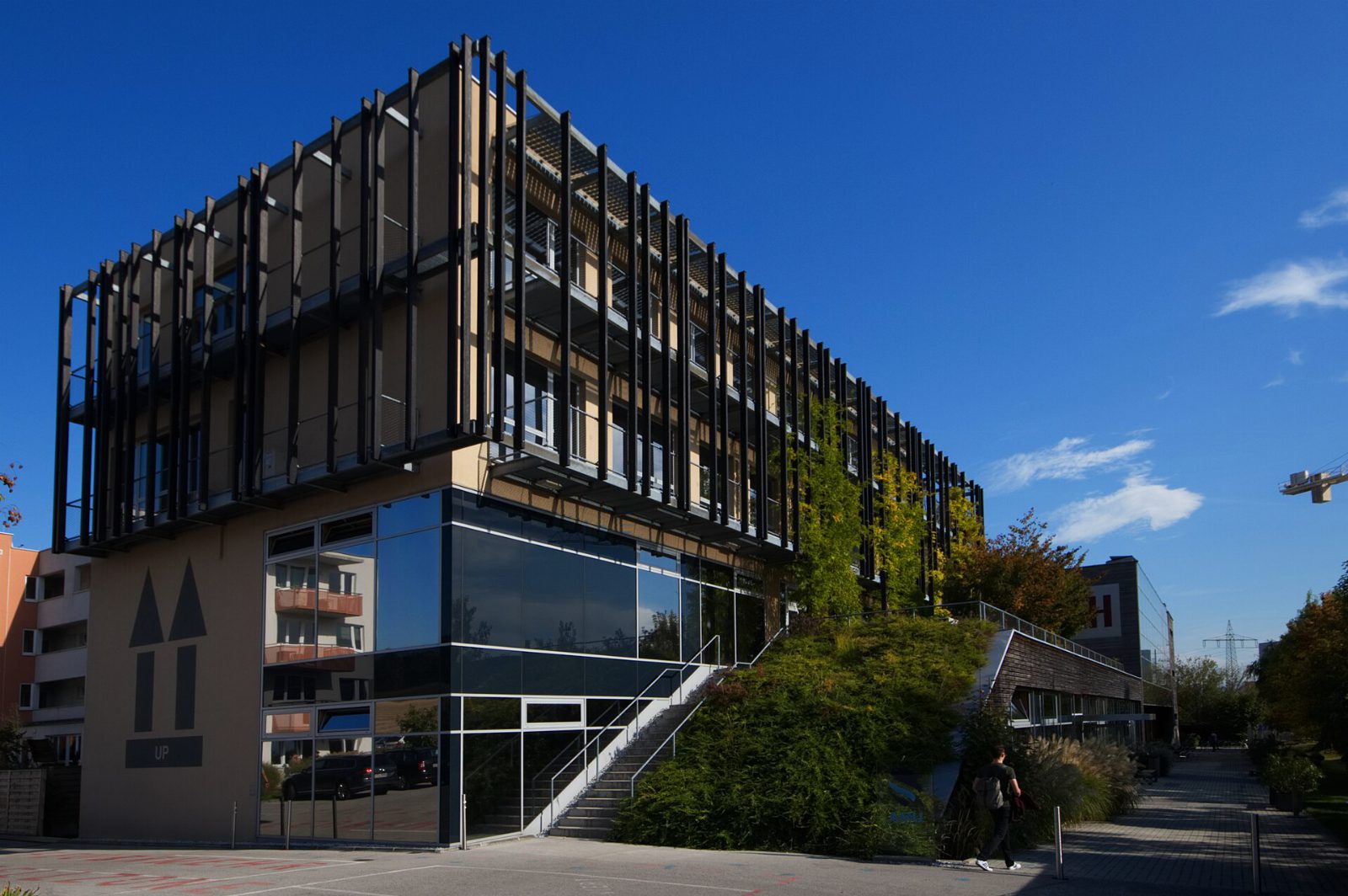 Campus Wieselburg der FH Wiener Neustadt, ein Bau mit Glasfront und dunklen Holzlamellen vor blauem Himmel