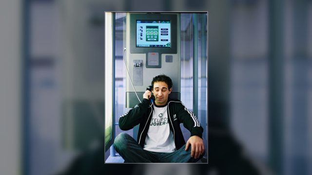 Gernot Kulis 2006 als Ö3-Callboy: Er sitzt mit dem Telefonhörer am Ohr am Boden einer Telefonzelle