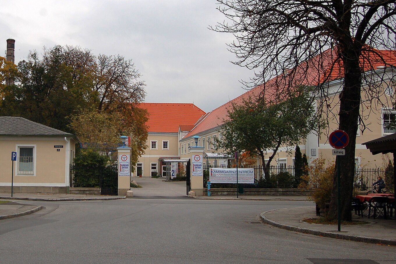 Einfahrt zum Kammgarnzentrum in Bad Vöslau mit Torpfeilern, Schild und herbstlichen Bäumen