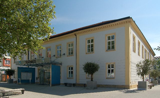 Rathaus Leobersdorf, ein zweistöckiger Bau mit gelben Fensterrahmen und einem Eingangsvordach mit der Aufschrift Rathaus
