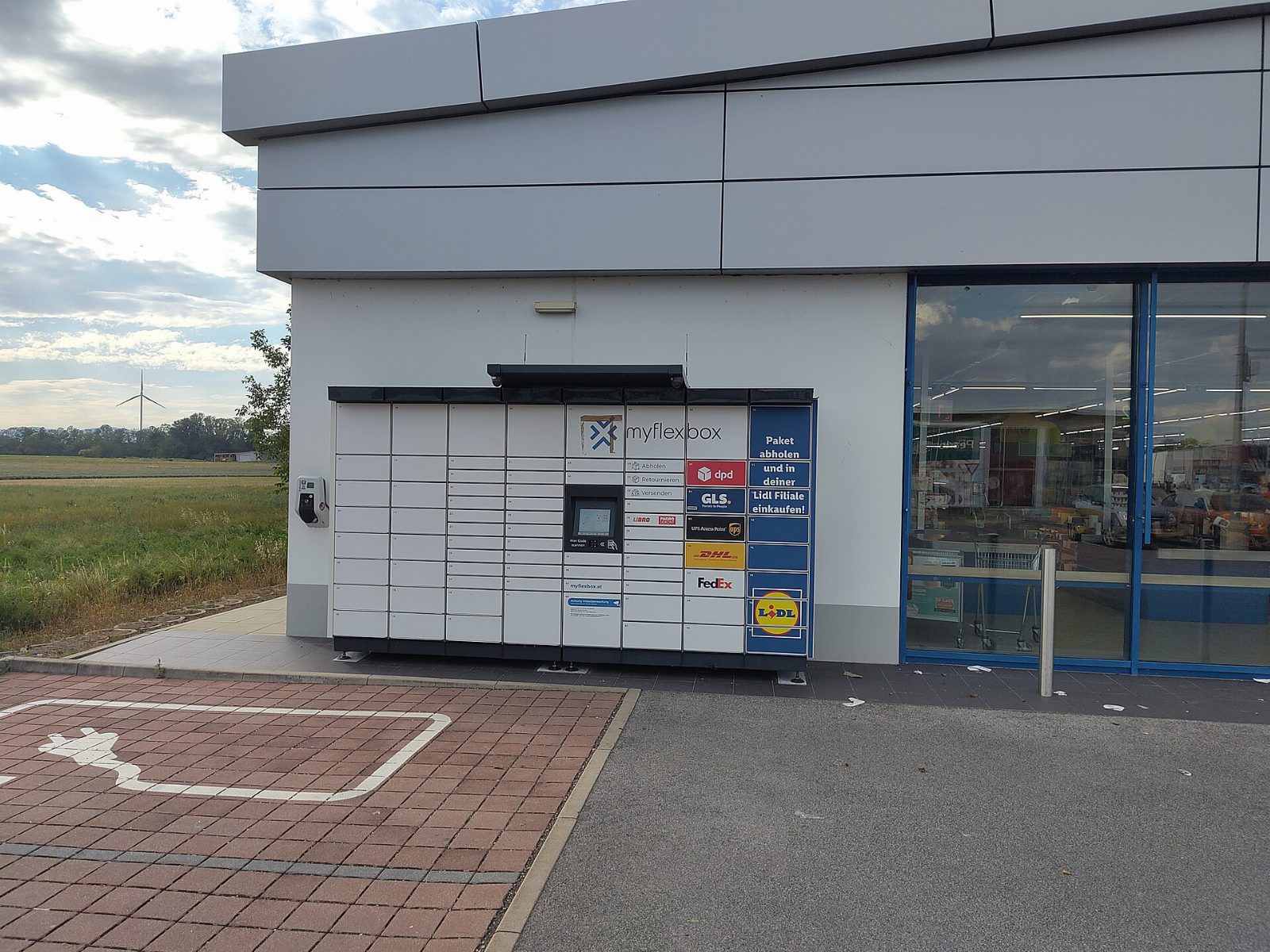 Lidl-Filiale in Ebreichsdorf mit Glasfront und Paketstation, daneben ein Parkplatz