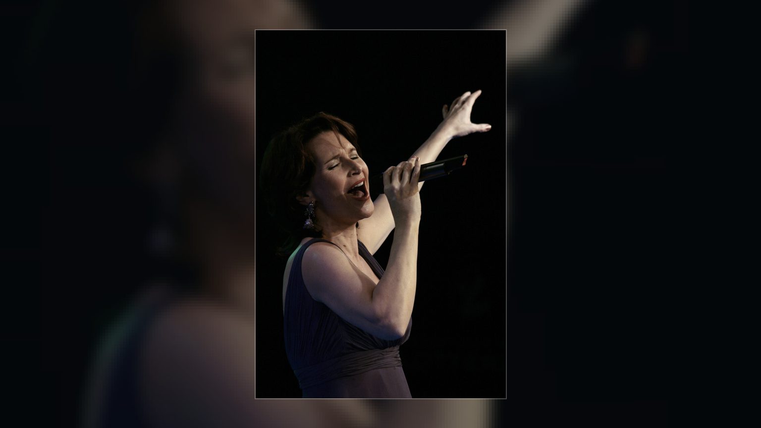 Maya Hakvoort singt mit erhobenem Arm und Mikrofon in der Hand vor dunklem Hintergrund, MiA-Awards 2009 in Wien