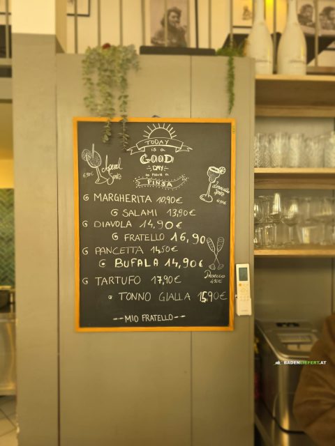 Kreidetafel mit acht Pinsa und ihren Preisen, darunter Diavola um 14,90 Euro