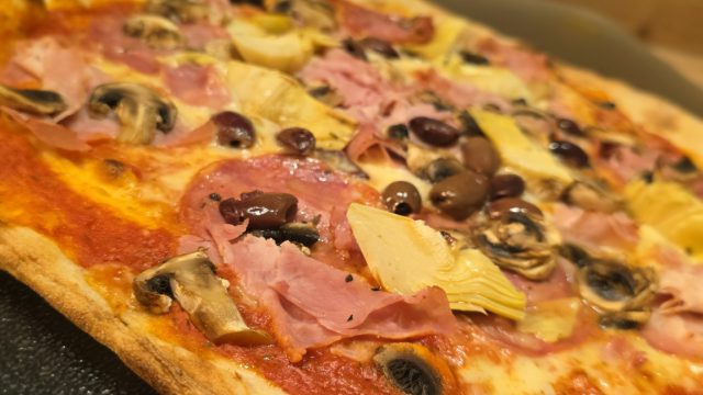 Pizza Capricciosa aus meiner Bestellung bei Osteria Anima mit reichlichem Belag und schmalem Rand.