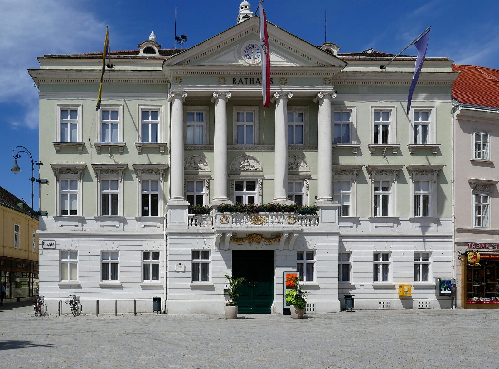 Das Rathaus der Stadt Baden am Hauptplatz mit Säulenportal und Fahnen