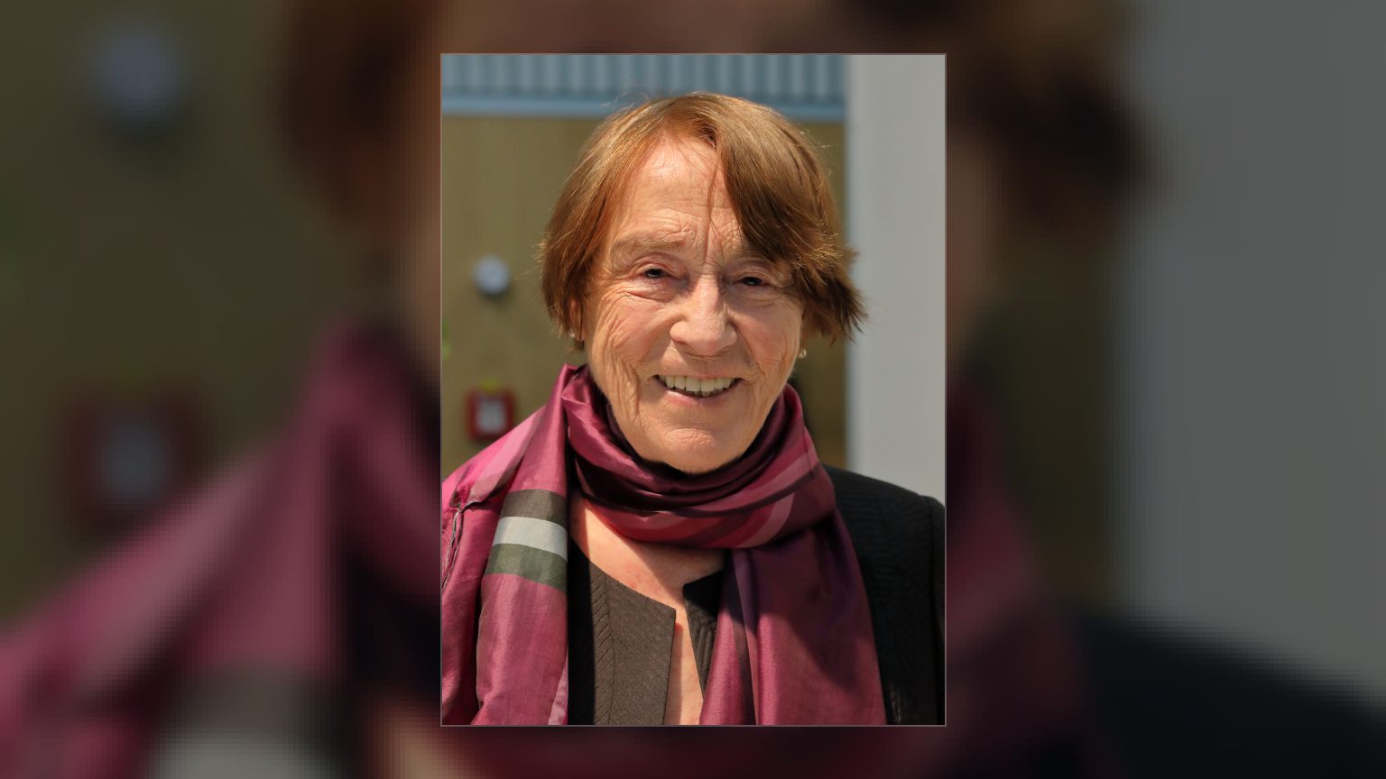 Renate Welsh lächelnd mit rotem Kurzhaar und weinrotem Seidenschal auf der Buchmesse Wien 2019