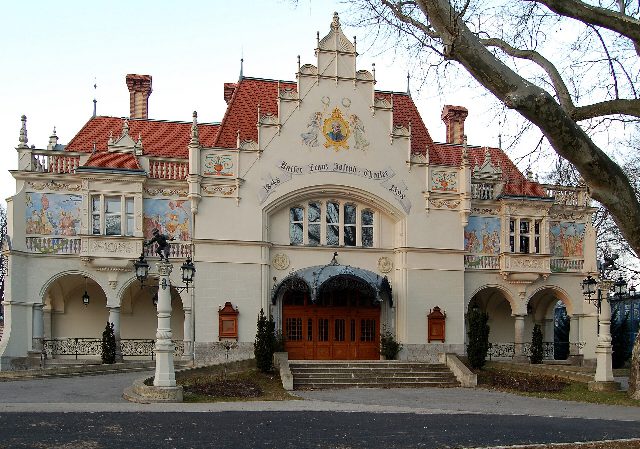 Fassade des Stadttheaters Berndorf mit Wandmalereien, Kaiserbild im Giebel und Holztor