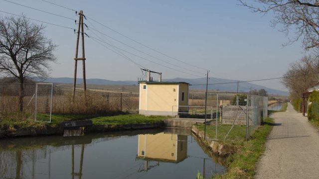 Kleinkraftwerk an der Schleuse 16 des Wiener Neustädter Kanals südlich von Baden: gelbes Turbinenhaus am Wasser, rechts der Treppelweg