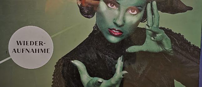 Plakat zum Musical Wicked der Bühne Baden: Darstellerin als grüne Hexe Elphaba mit spitzem Hut, daneben der Hinweis „Wiederaufnahme“