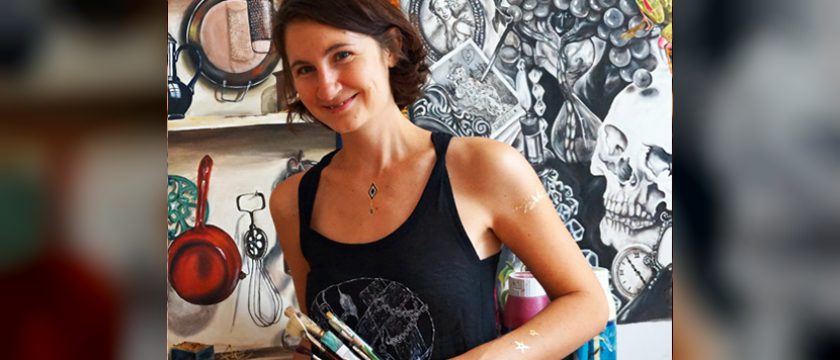 Elisabeth Patocka mit Pinseln in der Hand vor ihren großformatigen Bildern
